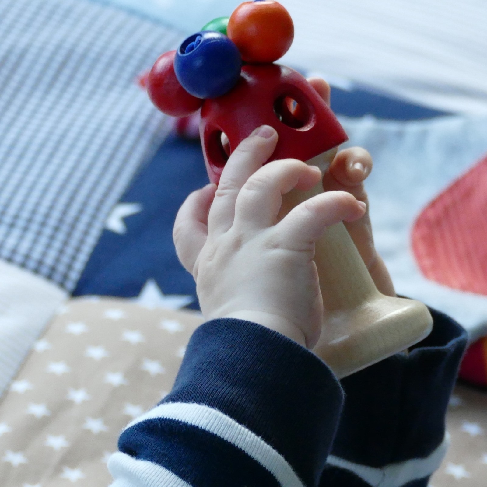 Baby-mit-buntem-Holzspielzeug